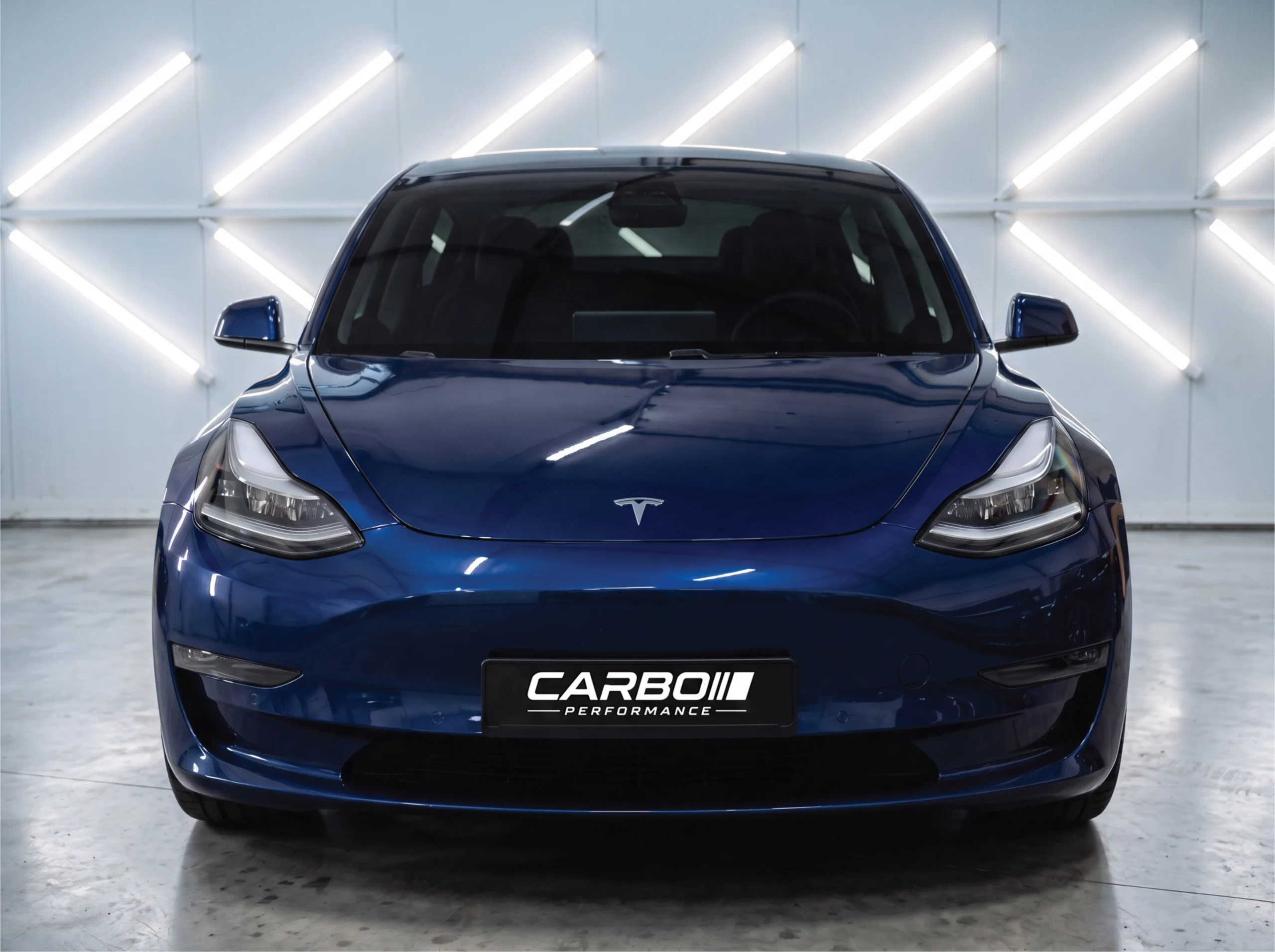 Carbo-Portofilo 12 Achterzijde van een blauwe nieuwe Tesla Model 3 Highland voorzien van Ramen Tinten Type B in de werkplaats